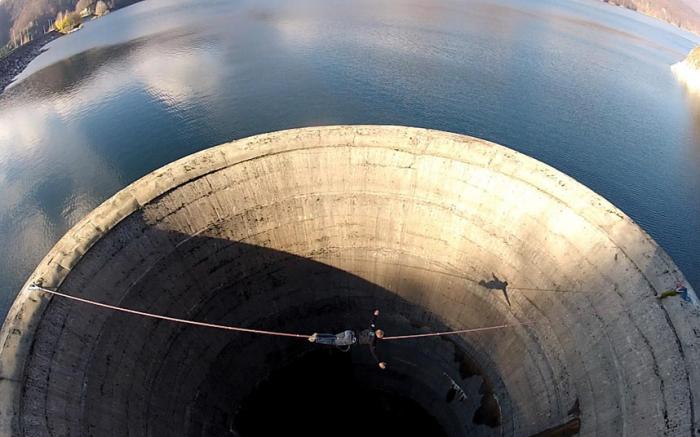 Смельчак слэклайнер пересекает 61-метровый слив водохранилища (10 фото)