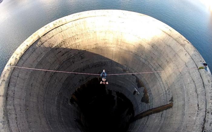 Смельчак слэклайнер пересекает 61-метровый слив водохранилища (10 фото)