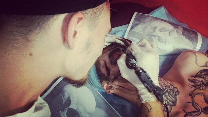 Юноша «украсил» лицо татуировкой с изображением черепа (4 фото)