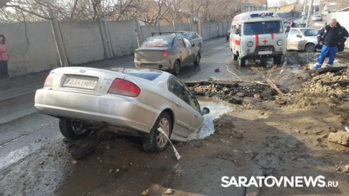 В Саратове автомобиль провалился в огромную яму на дороге (6 фото)