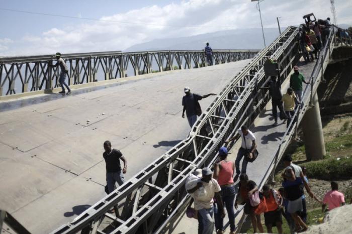 Опасная переправа по рухнувшему мосту в Гаити (7 фото)