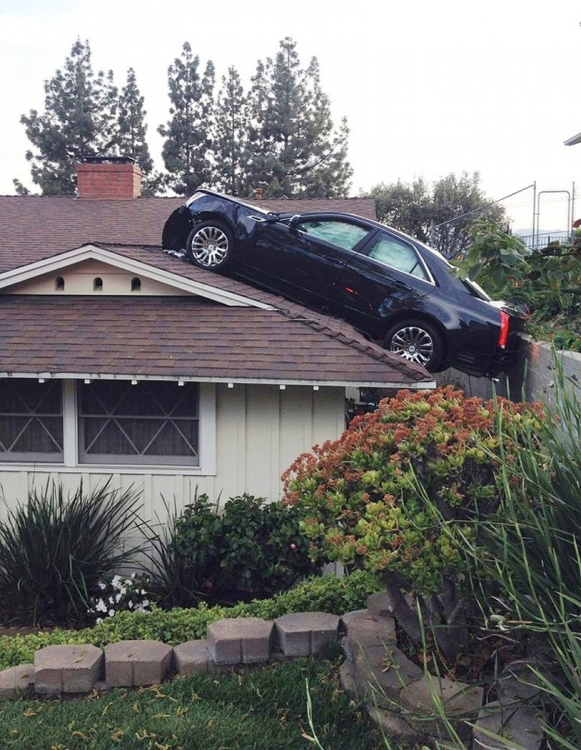 Водитель удачно посадил авто на крышу соседского дома (7 фото)