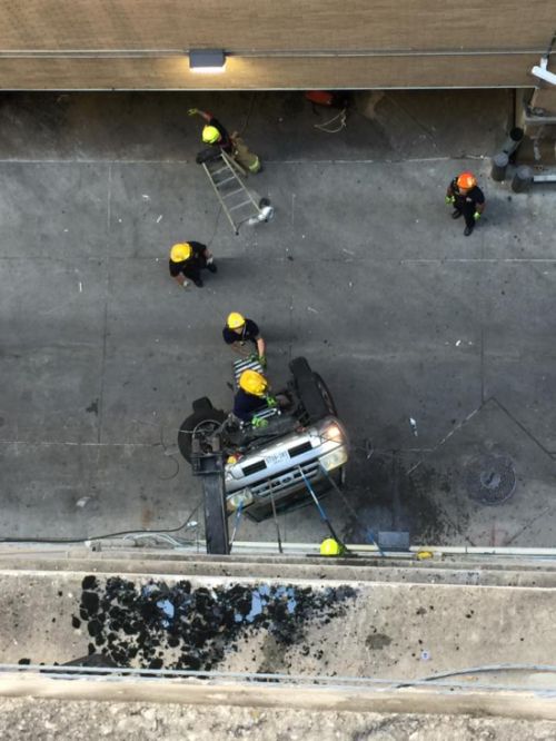 Свалившийся с 9 этажа парковки автомобиль зацепился за провода (6 фото