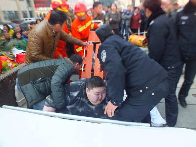 Прохожие и спасатели два часа пытались поднять упавшего на землю толстяка (6 фото)