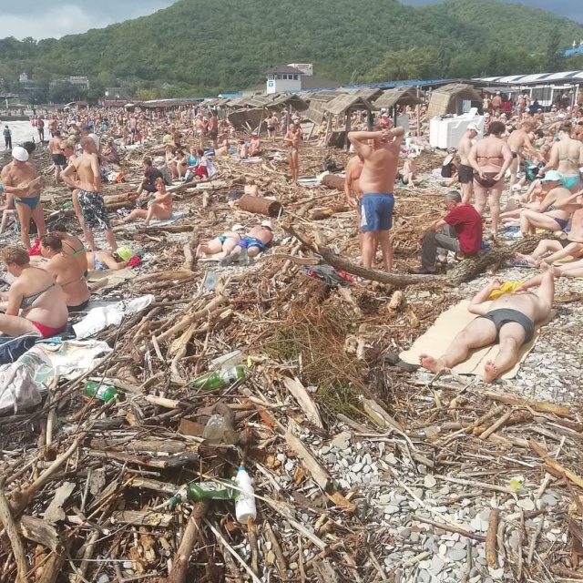 Разрушенный пляж и горы мусора не помеха для отдыхающих (2 фото)